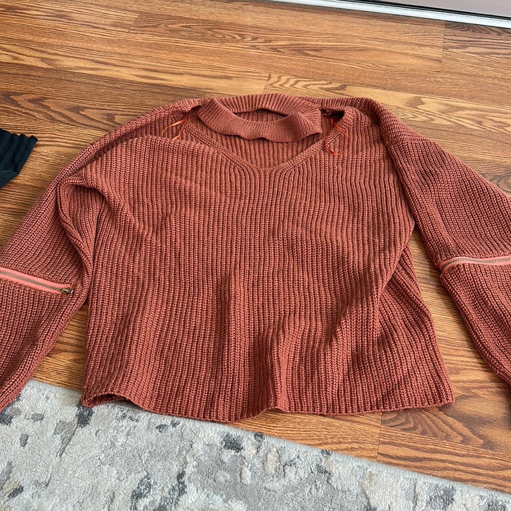 Woman’s sweater with zipper detail on sleeves and cut out neckline